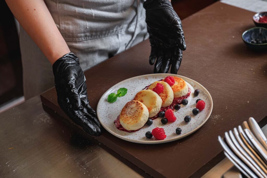 chef decorated cheesecakes with berries cream and L6U7L8X